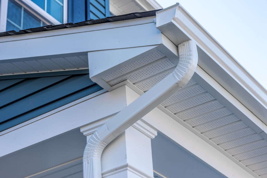 colonial white gutter guard system, fascia, drip edge, soffit providing ventilation to the attic, with pacific blue vinyl horizontal siding at a luxury american single family home neighborhood usa